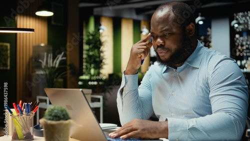 Fotografie Black man consultant enjoying a cup of coffee to stay awake late at night, handling administrative tasks in the corporate space