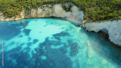 Cliffs and hidden beach cove with clear blue waters in summer Kefalonia Greece