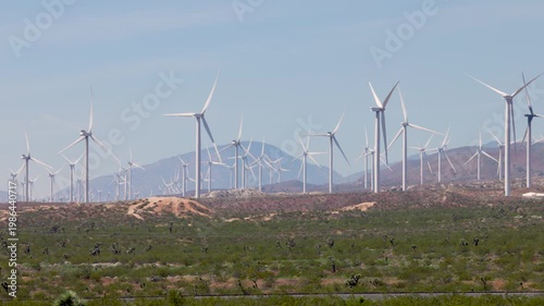 4k footage of many wind turbines generating natural energy in a wind farm from ground level.