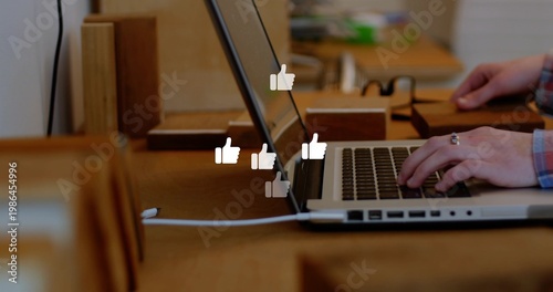 Typing hands in plaid shirt, ringed, pressing keys on laptop at wood table, showing like overlays