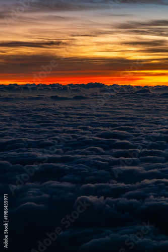 Aerial view above clouds at sunrise