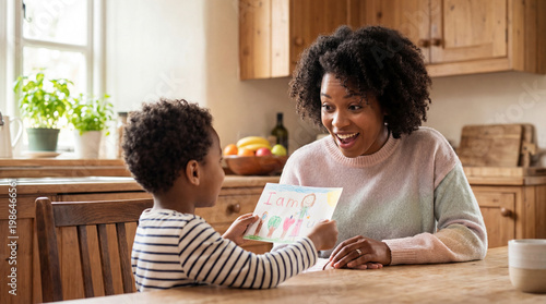 Mother's Day card giving moment with son presenting handmade gift to mom showing appreciation joy for lifestyle magazine editorial photography