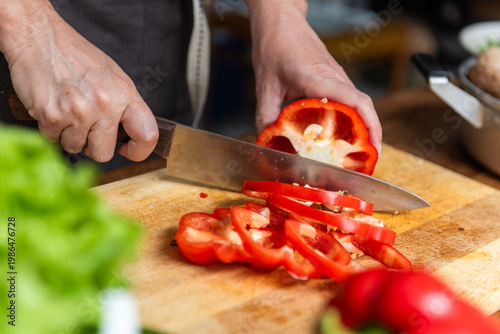 Fotografia Slicing fresh red bell pepper