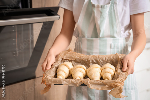 Female baker putting baking...