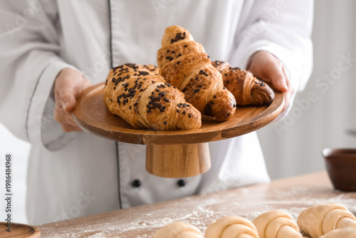 Female baker holding wooden...