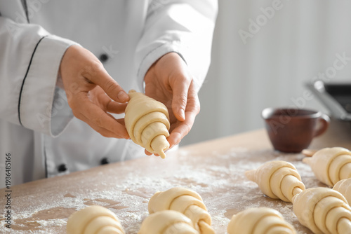 Female baker making croissa...