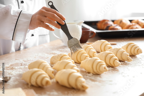 Female baker greasing raw c...