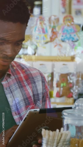 Vertical video: Shop clerk tapping tablet, scrolling, showing digital prices updating sweets stock