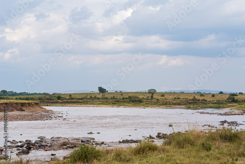 rocky banks along river bend as waters flow through northern serengeti savanna landscape in tanzania