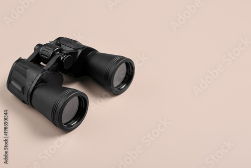 Modern binoculars on beige ...