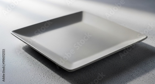 Elegant Square Plate on a Table Minimalist Design and Shadow Play.