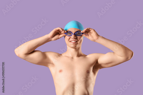 Male swimmer putting on gog...