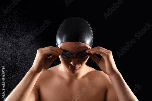 Male swimmer putting on gog...
