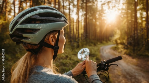 Woman wearing bicycle helmet on trail with sunlit forest background