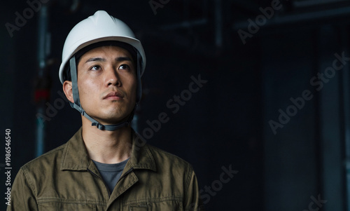 上を見上げる真剣な表情の男性作業員 、採用や求人のイメージ