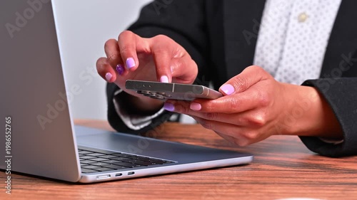 Professional woman multi-tasking with mobile phone and computer in office