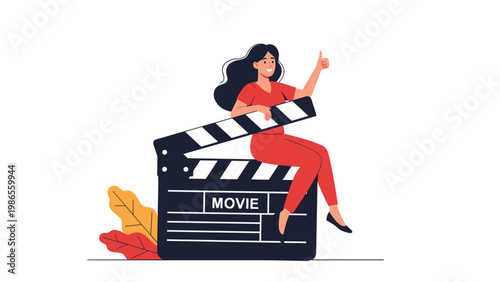 Happy woman filmmaker sitting on a large movie clapperboard while giving an enthusiastic thumbs up for a successful take.