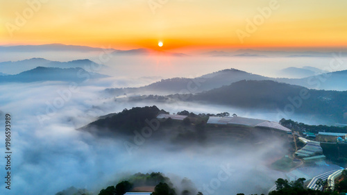 фотографія A breathtaking sunrise over a sea of clouds in the highlands, where soft layers of mist drift between rolling hills