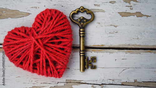 hand crafted red heart and old vintage key on wooden table top view.ai 