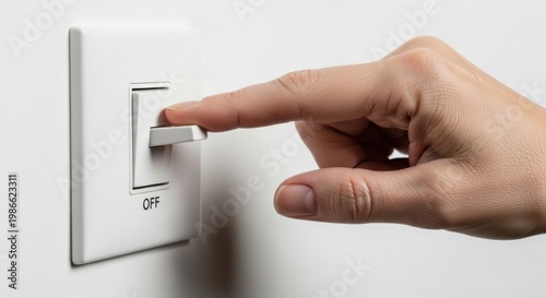 Hand Turning Off Light Switch on White Wall