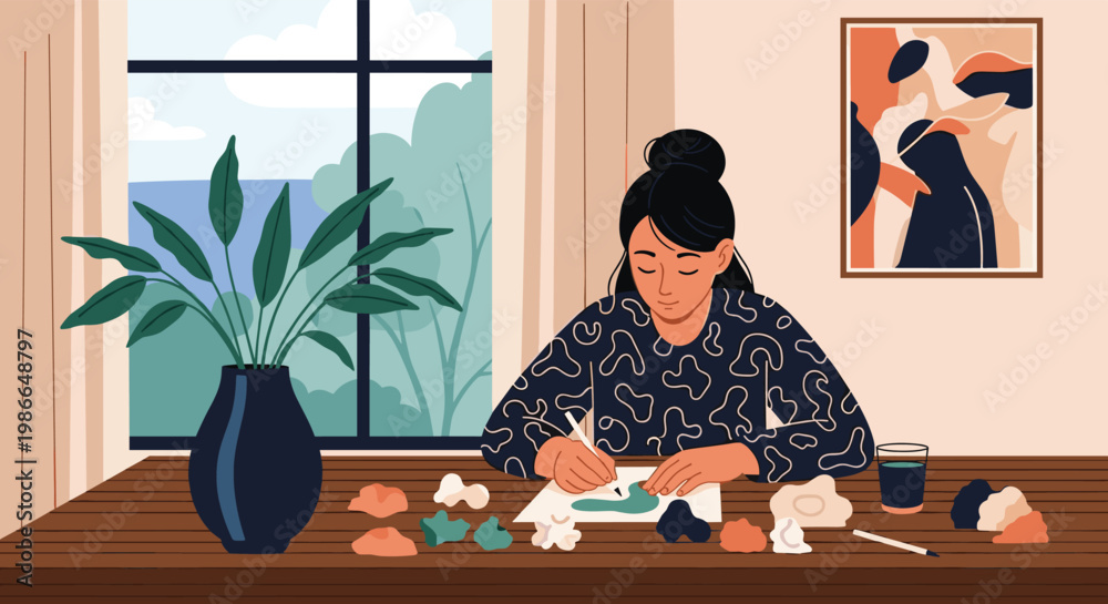 Fototapeta premium Creative female artist focuses on her painting while working at a wooden desk near a window with garden views.