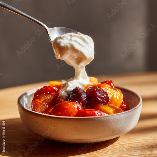 A spoonful of yogurt topping a colorful fruit salad.