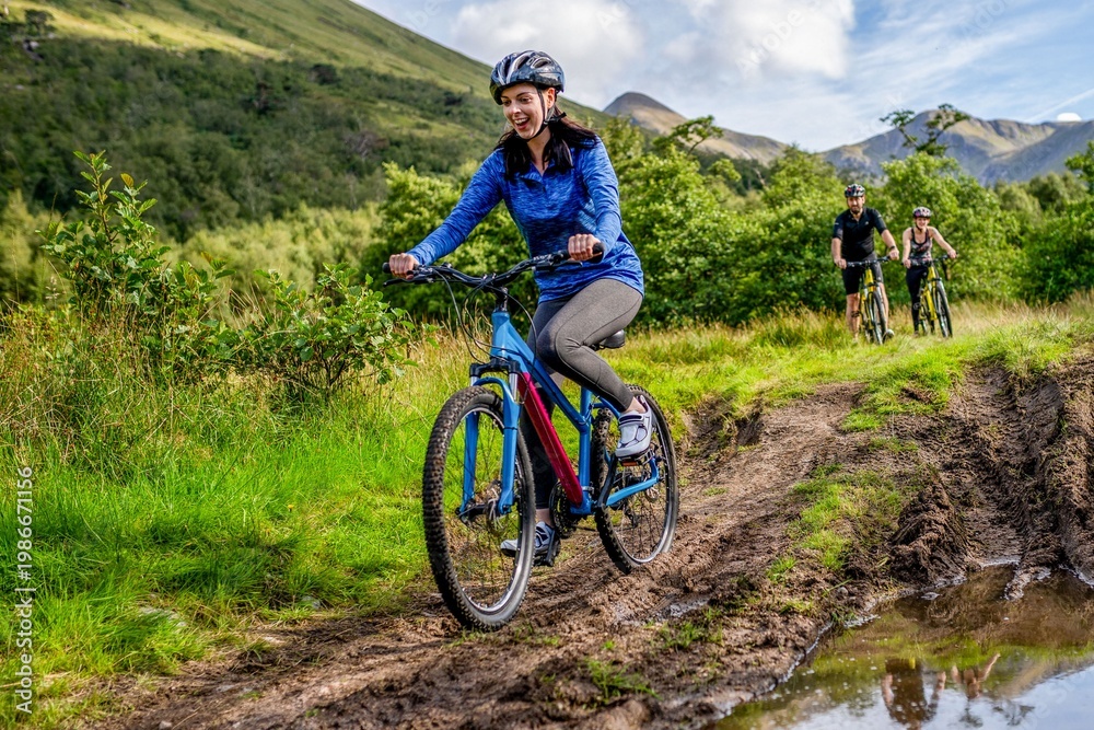Fototapeta premium Cyclists enjoying muddy trail adventure.