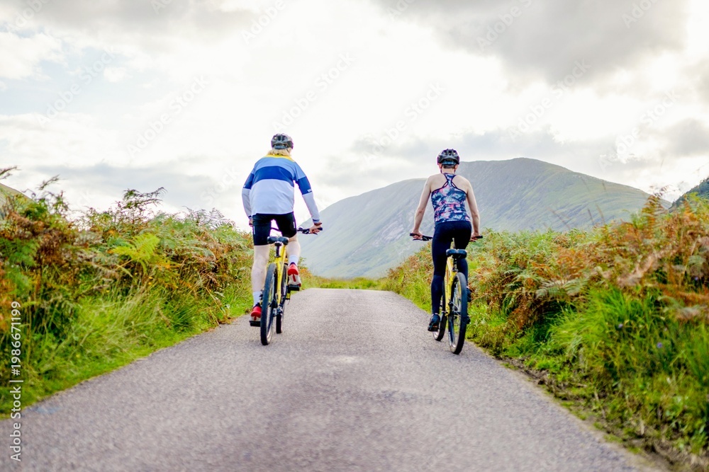 Fototapeta premium Cyclists exploring scenic mountain path