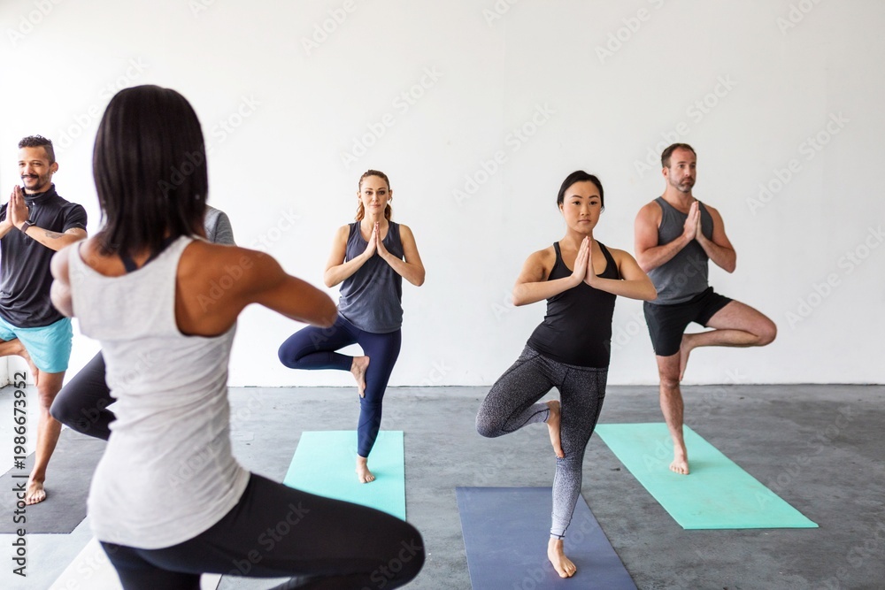 Fototapeta premium Group practicing yoga poses together.