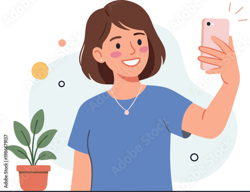 Woman takes selfie with phone and plant on table indoors happily