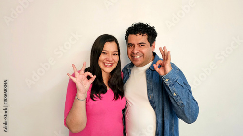 Latino man and woman in their 40s show their love to celebrate Valentine's Day and their anniversary with kisses and hugs, laughing and smiling