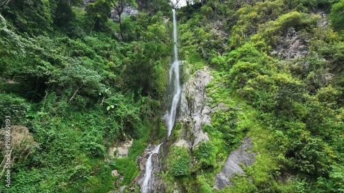 Stunning Wide View of Majestic Waterfall Flowing Down Green Mountain