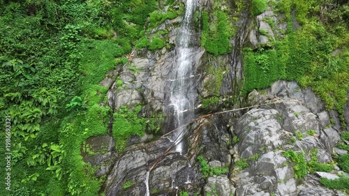 Fresh Waterfall Cascading Down Steep Rocky Mountain Cliff Face