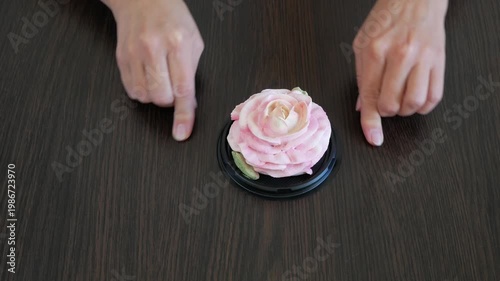 Hands draw a heart on the table around a marshmallow rose flower. Holiday gift. Love.
