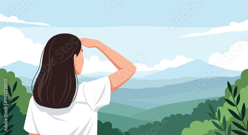Young woman stands with her back to the camera while looking out at a vast and beautiful mountain range landscape.