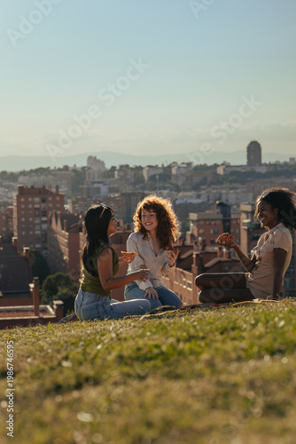 Canvastavla Multicultural female friends enjoying picnic with pizza at city park