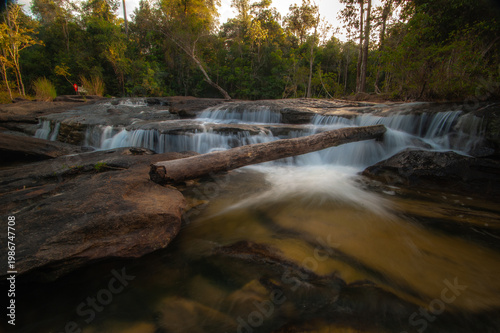 A waterfall cascading down rocks in the forest amidst nature.