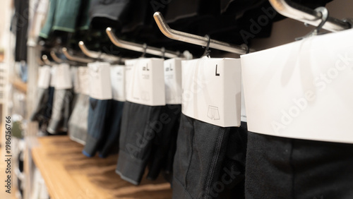 Cuadro en lienzo close-up of men's underwear in white minimalist packaging hanging on metal display racks in a modern retail clothing store