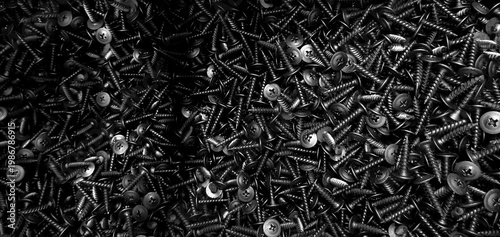 Scattered black screws, part of the image is blurred
