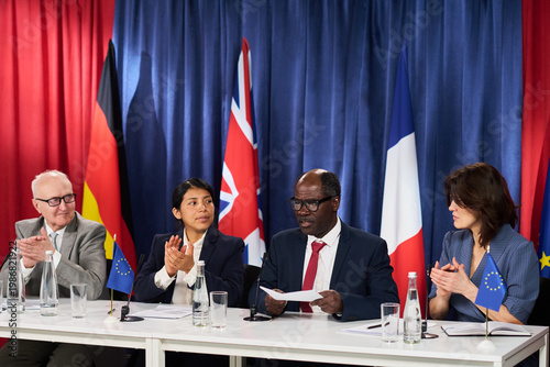 Canvastavla Diverse diplomats presenting statement during international press conference, applauding agreement before European flags