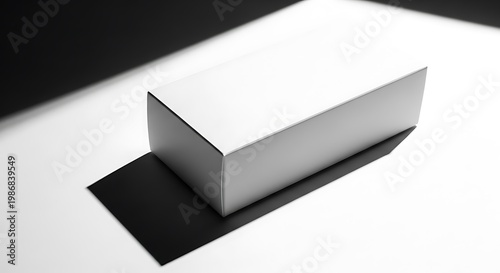 A stark, minimalist studio shot of a white rectangular box casting a sharp shadow on a monochrome background, perfect for product display and graphic design elements