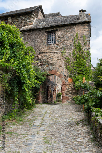 Historic cobblestone streets and medieval buildings in Conques village, Romanesque church, France