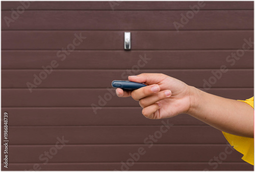 Garage door PVC. Hand use remote controller for closing and opening garage door
