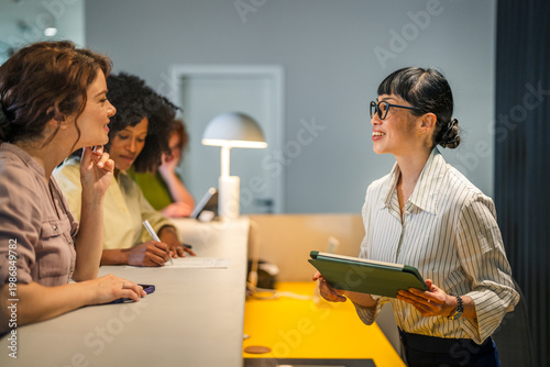 Tableau sur toile Diverse women communicating and collaborating at modern office reception
