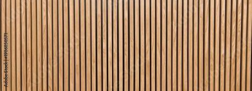 Vertical wooden slats forming a textured wall panel in varying shades of natural brown.