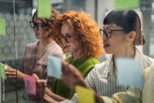 Diverse businesswomen brainstorming creative ideas using sticky notes