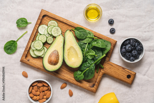Avocado, spinach, almonds, cucumber and blueberries ingredients for healthy summer salad top view