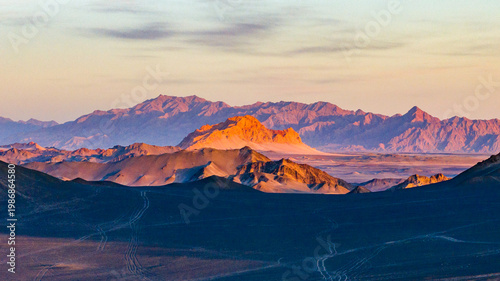 Foto Sunset light illuminating Yanzhi Mountain beyond the dark ridges of Heidu Mountain in Qinghai, China