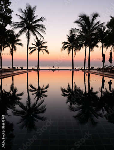 Dämmerung mit spiegelndem Pool, Palmen und Meer, Urlaub