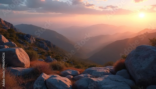 Rocky mountain peaks at sunset with soft pastel sky. Hazy valleys stretch to distant ridgelines. Sun glows on rugged terrain, highlighting nature raw beauty and peacefulness.